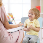 Child psychologist working with young boy in office