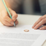 woman signing marriage divorce papers