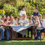 big family eats by their garden