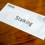 Front of envelope reads stalking on top of wood floor