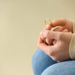 Woman holding ring, closeup. Concept of divorce