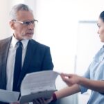 Grumpy chief and his female office worker arguing over documents