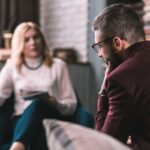 Bearded man wearing glasses feeling concerned visiting therapist