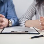 Couple with divorce contract and ring on desk. Divorce