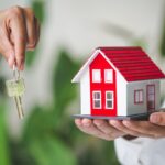 Your new house, real estate agent holding house key to his clien