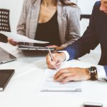 Caucasian man signing contract, hand putting signature on official document, biracial clients customers couple make purchase or sign midmarriage agreement concept.