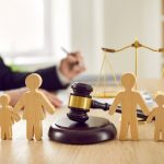 Gavel and family figures on judge's table illustrating concept of divorce and child custody