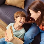 A mother shares a happy moment reading with her hearing impaired son.